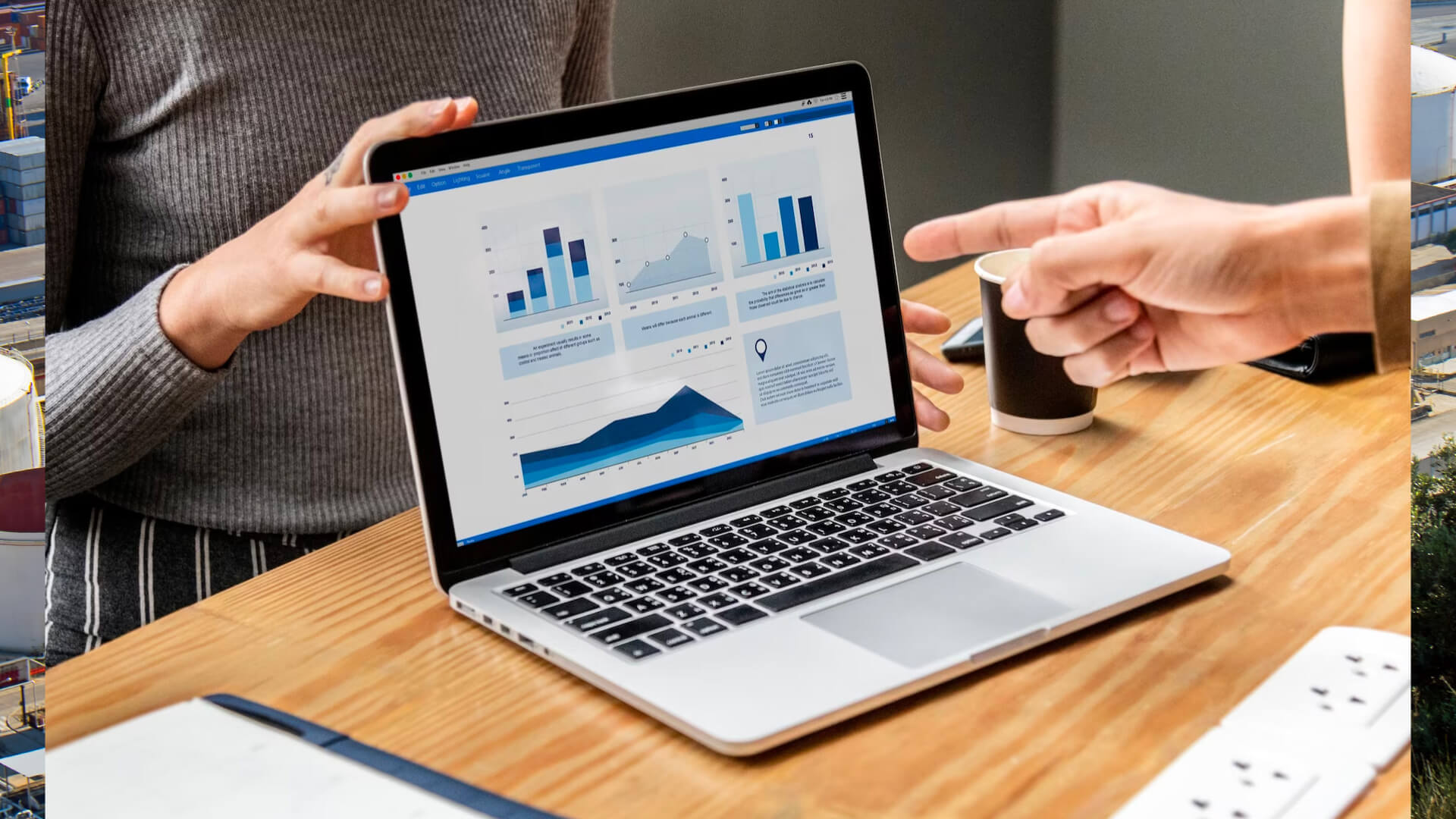 Two people by a laptop with analysis graphics